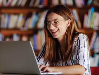 K-12 student on laptop in library