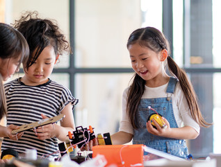 three k-12 students working together on a robotics project