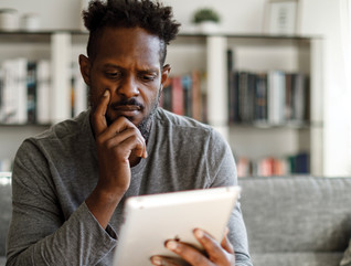 Man looking suspiciously at tablet 