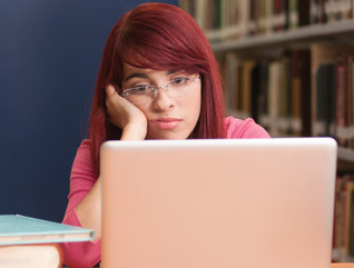 sad student on laptop in library