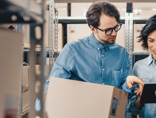 Co-workers using tablet to check inventory