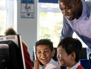 Teacher working with students at computer
