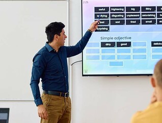 High school teacher using smartboard while teaching students in the classroom.