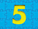 yellow numeral 5 in the negative space of blue puzzle pieces