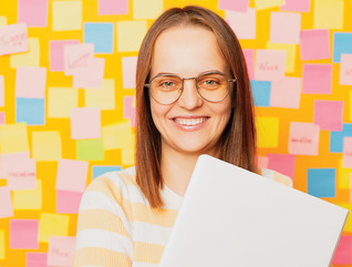 Teacher in front a wall covered in post-it notes