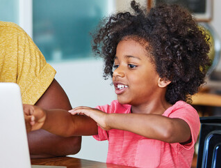 Parent using laptop with child