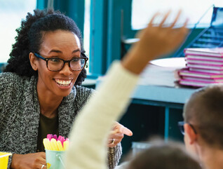 K12 teacher interacting with students in classroom