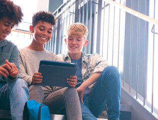 K12 students using tablet on school stairwell with great wi-fi