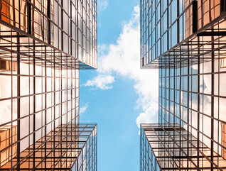 Digital twins concept showing the sky between two glass buildings