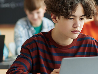 Boy using laptop computer in class