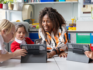 Teacher helping students with tech