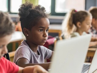 Young students working on laptops in school