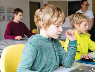 students on laptops in classroom