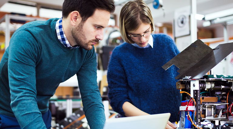 Teacher and student working on machine
