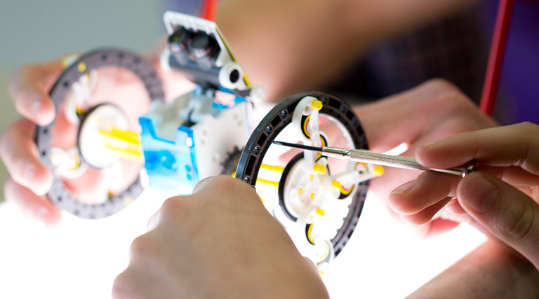 Person tinkering with robot