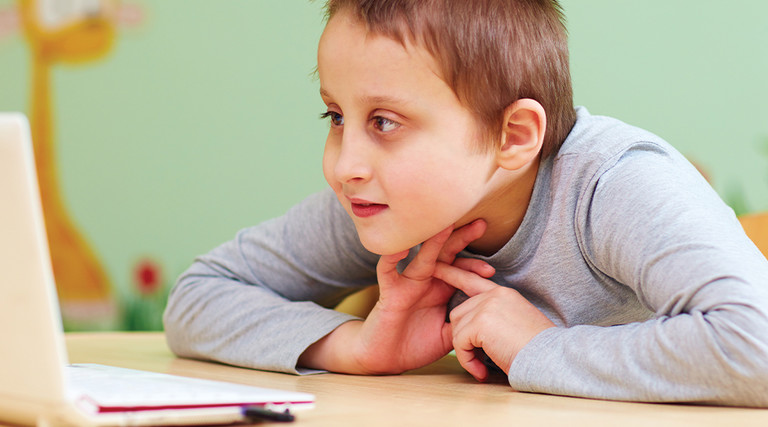 Young boy with special needs using laptop