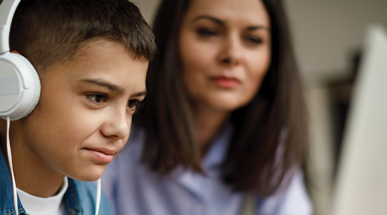 Boy doing online learning with parent