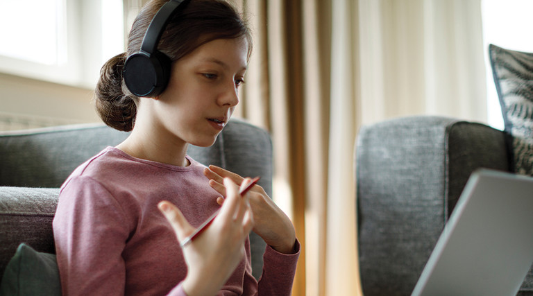 girl with headphones using laptop