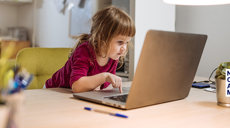 young girl using internet on parent's laptop