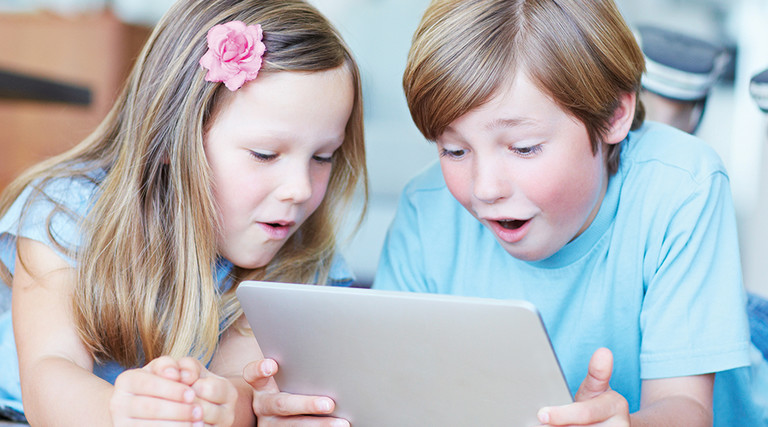 Two kids using a tablet for digital learning 