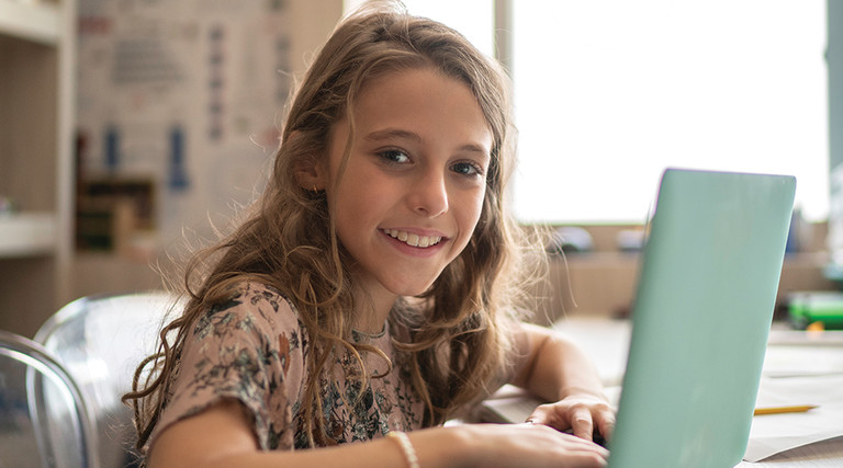girl remote learning on laptop at home