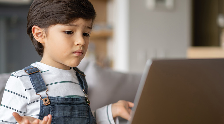 young boy looking at laptop screen for e-learning