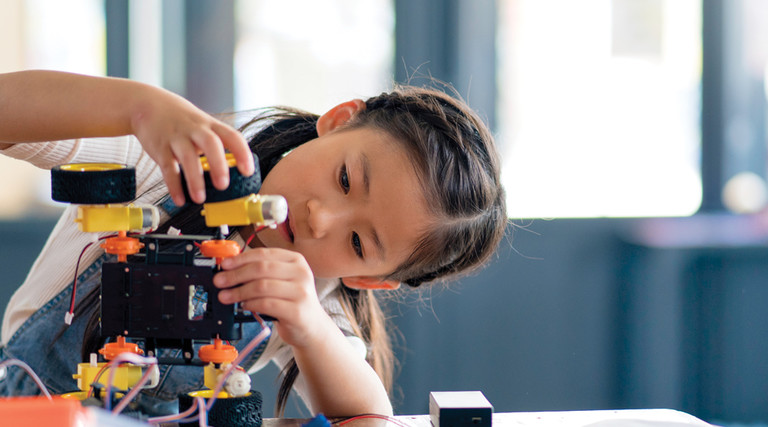 K–12 student building a robot with wheels