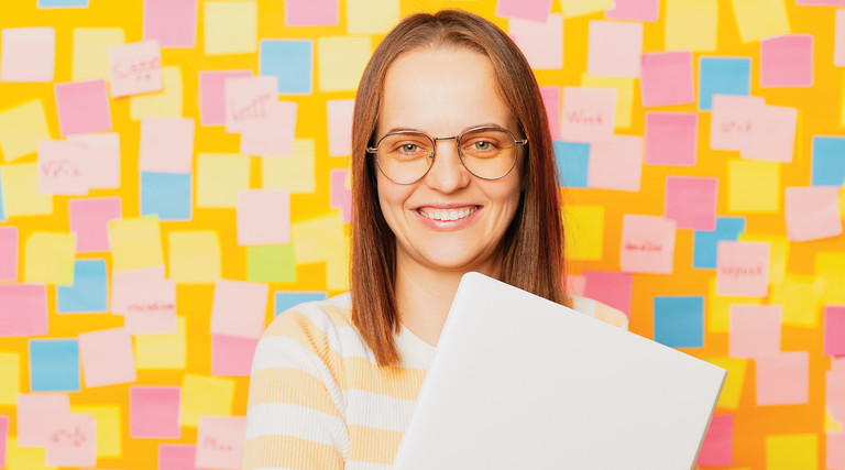 Teacher in front a wall covered in post-it notes