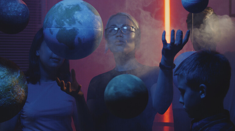 Teacher teaching astronomy with planet models