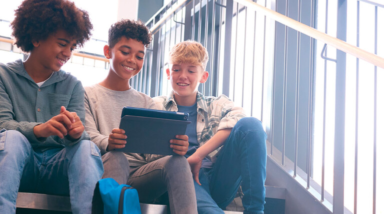K12 students using tablet on school stairwell with great wi-fi