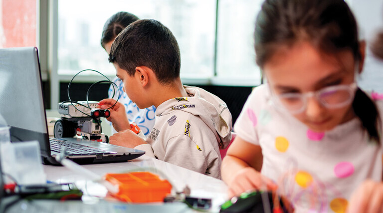 A group of children work together on some type of technology project