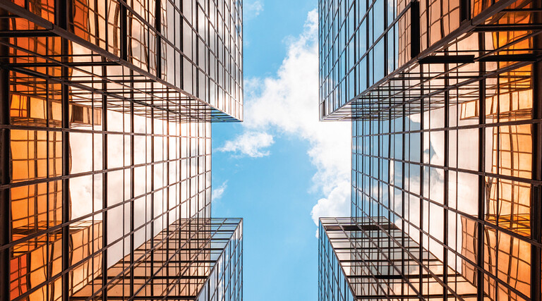 Digital twins concept showing the sky between two glass buildings