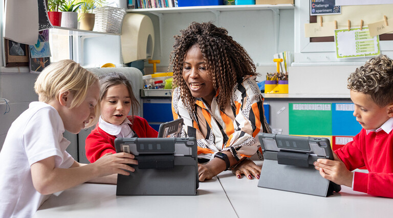 Teacher helping students with tech