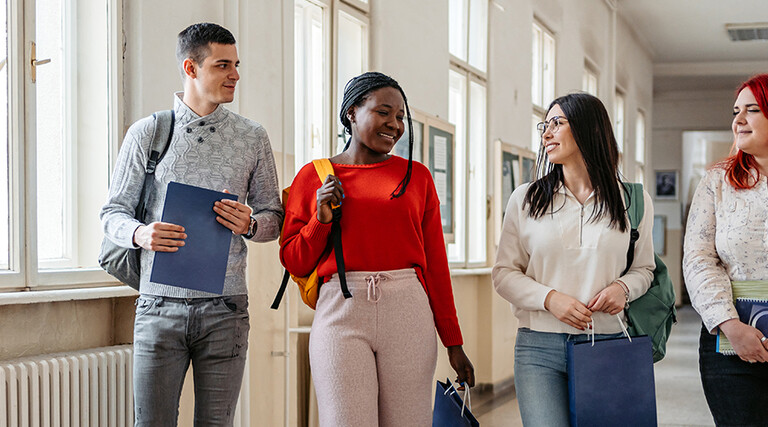 Students walking down the hall and talking.