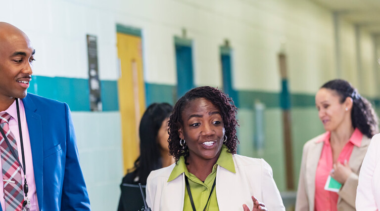 Diverse group of educators walking in hallway