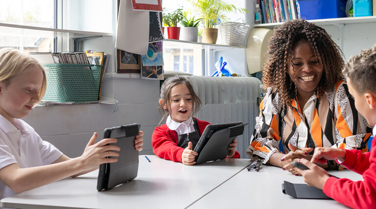 Teacher helping students using tablets
