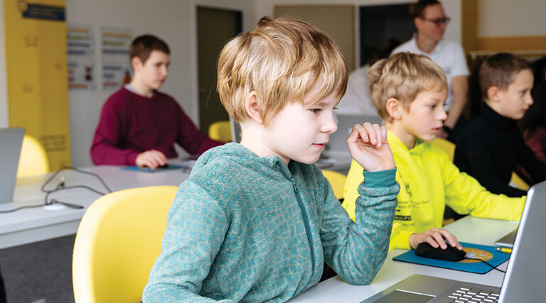 students on laptops in classroom