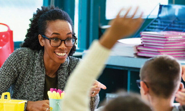 K12 teacher interacting with students in classroom
