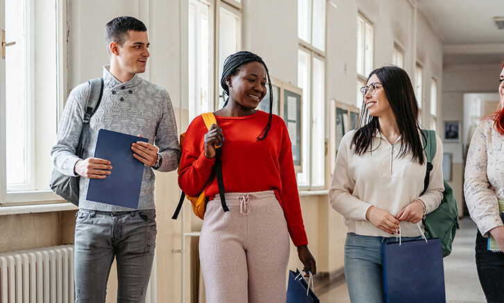 Students walking down the hall and talking.