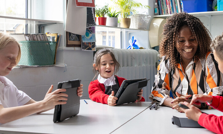 Teacher helping students using tablets
