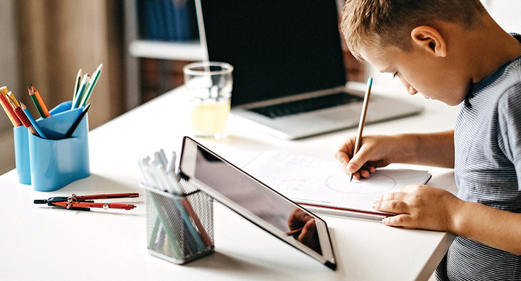 boy using laptop at home for learning