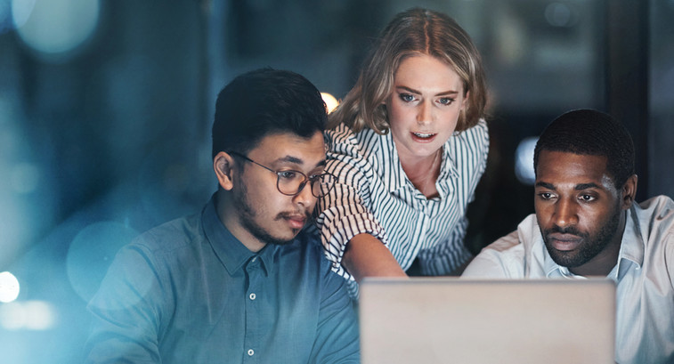 Three people looking at a laptop screen.