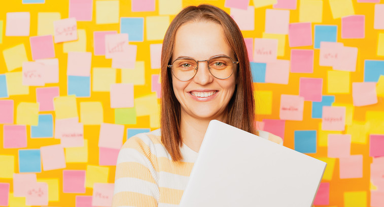 Teacher in front a wall covered in post-it notes