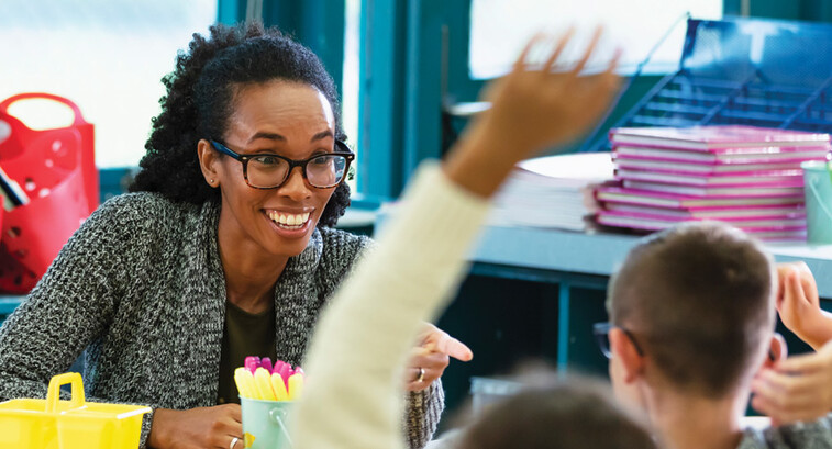 K12 teacher interacting with students in classroom