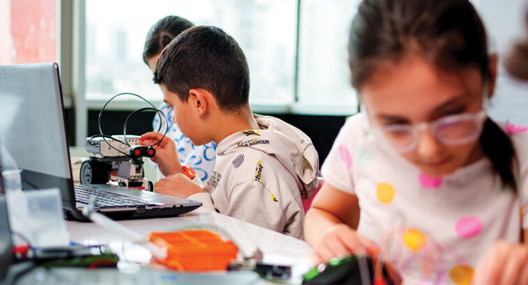 A group of children work together on some type of technology project