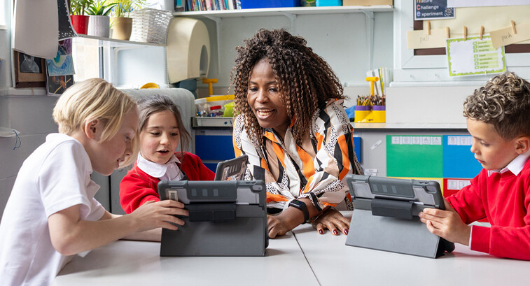 Teacher helping students with tech
