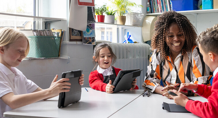 Teacher helping students using tablets