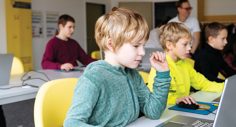 students on laptops in classroom
