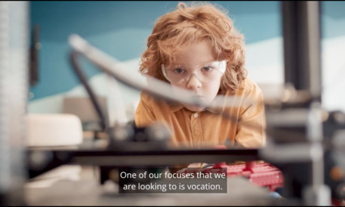 K–12 student watching 3D printer