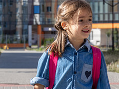 primary school student with a backpack goes home from school